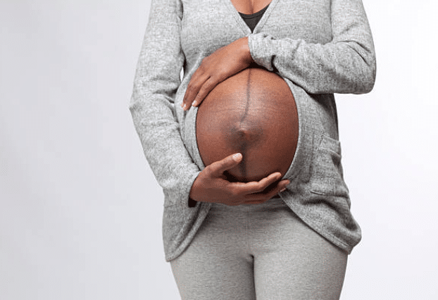 Black women holding her pregnancy bump